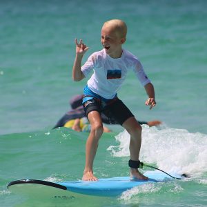 Boy learning to surf at surf lessons