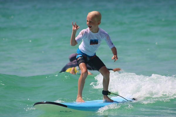 Boy learning to surf at surf lessons